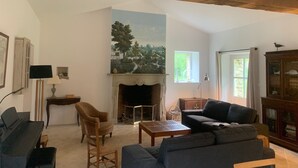 A living room with a fireplace, a sofa, a chair, and a dining table.