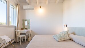 A bedroom with a bed, a desk, a chair, a mirror, and a window. - Moon – Double Room with Private Bathroom (Quartu Sant'Elena)