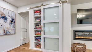 Una habitación con puerta corrediza de vidrio, chimenea y televisor montado.