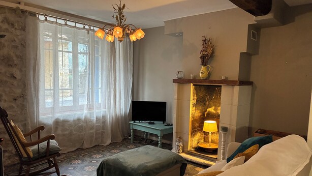A room with a bed, a rocking chair, a television, and a fireplace. - Spacious Village House with Garden in Ginoles (Ginoles)