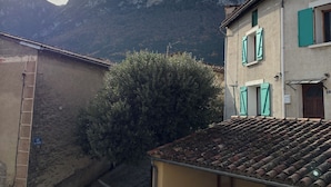 A building with a tiled roof, a bench, and a sign indicating a parking area. - Spacious Village House with Garden in Ginoles (Ginoles)