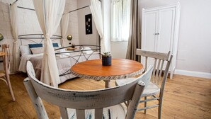 A bedroom with a bed, a bedside table, a chair, a round table, and a canopy bed. - L'Accademia dei Sogni (Sassari)