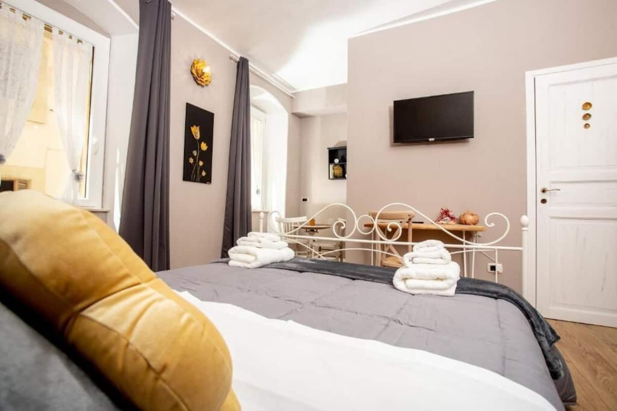 Une chambre d’hôtel équipée d’un lit, d’un bureau, d’une télévision et d’une armoire.