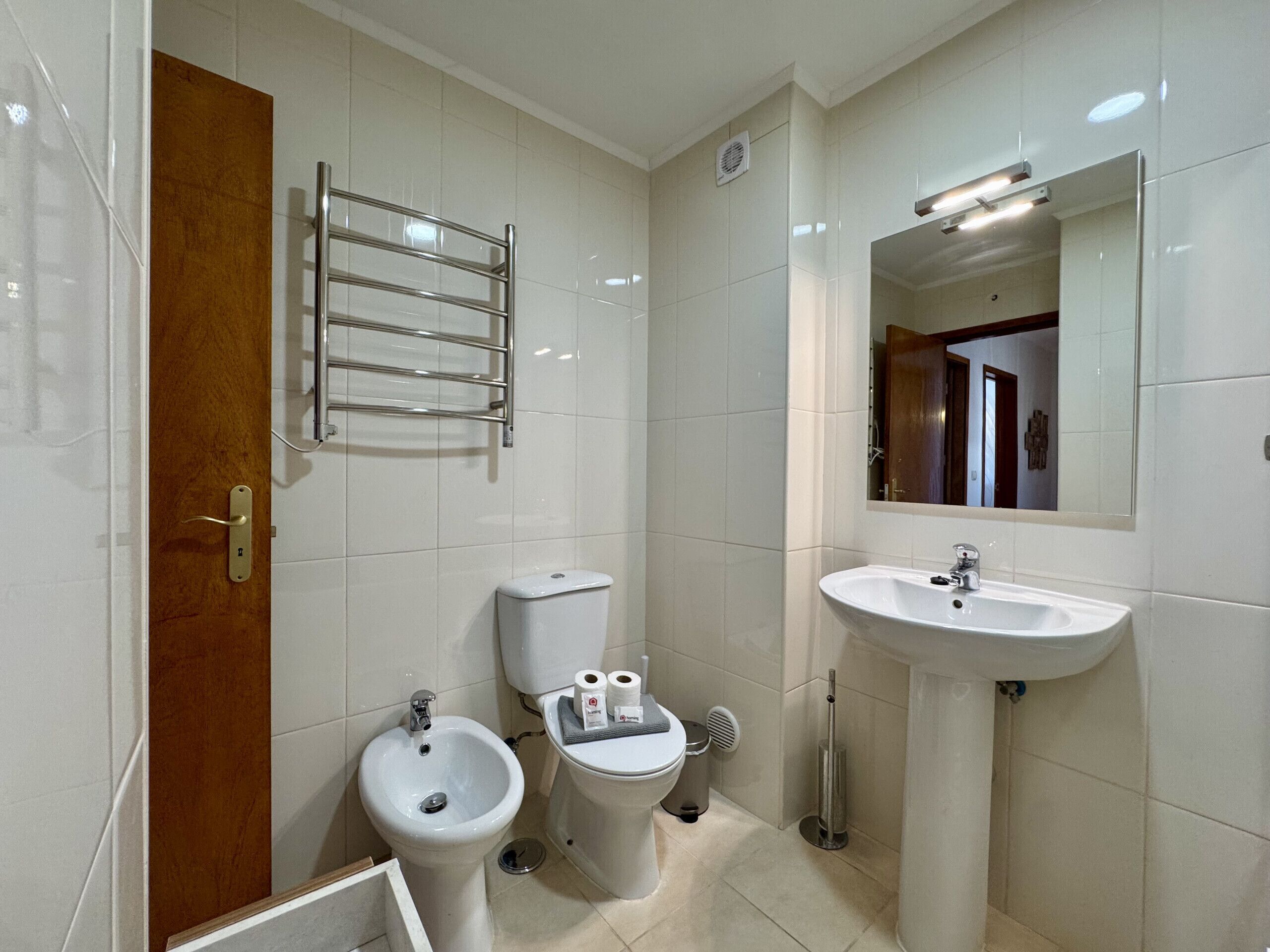 Ein Badezimmer mit Toilette, Bidet, Waschbecken, Spiegel und Handtuchhalter.