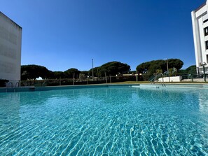 Ein klares Schwimmbecken mit Blick auf umliegende Gebäude und Bäume.