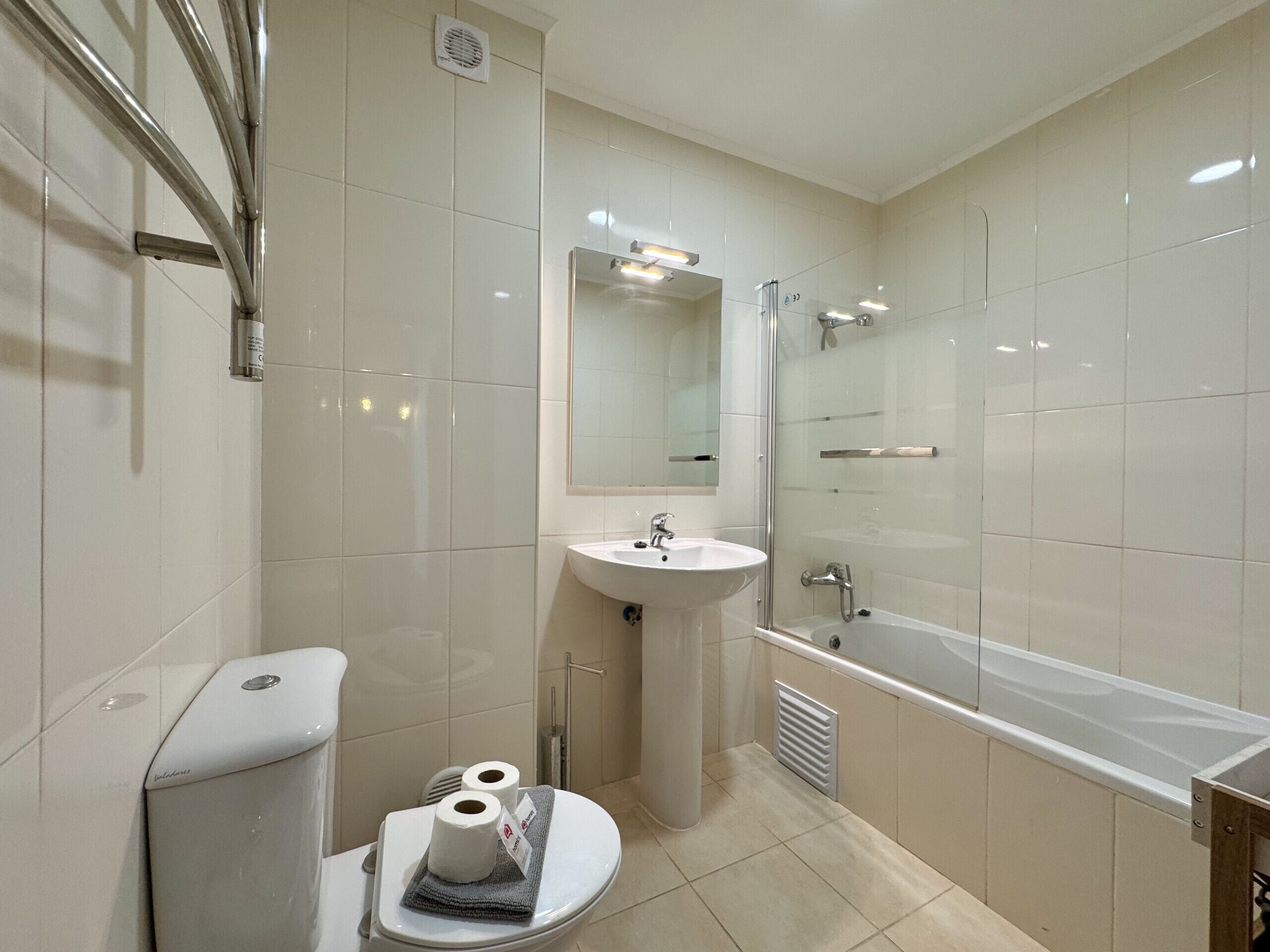 Ein modernes Badezimmer mit Toilette, Waschbecken und Badewanne.
