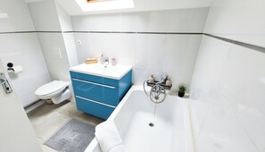 Een haardroger, handdoeken, zeep, toiletpapier