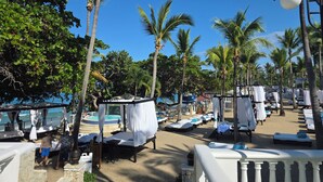A beachside resort with overwater bungalows, palm trees, and a pool area. - Spacious 5-bedroom villa/AC at beach resort
15 restaurants/bars. 
All Inclusive! (Cofresi)