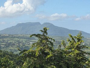 Un paysage montagneux avec une vallée et quelques bâtiments dispersés.