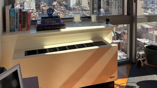 A desk with books and candles, a view of a city skyline through large windows. - Luxury NYC Penthouse with Amazing Views (New York)