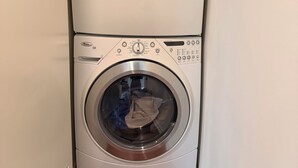 A stacked washer and dryer unit in a laundry room. - Luxury NYC Penthouse with Amazing Views (New York)