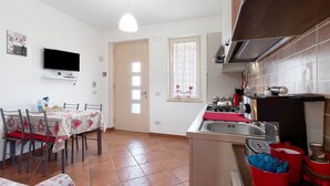 Une cuisine équipée d’une cuisinière, d’un évier et d’un coin repas avec des chaises et une table.