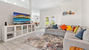 Una sala de estar moderna con televisor, sofá y alfombra estampada.