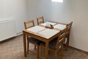 A dining table with four chairs, a small plant, and a white radiator. - BELLESTAY/Suite for 4 (Brașov)