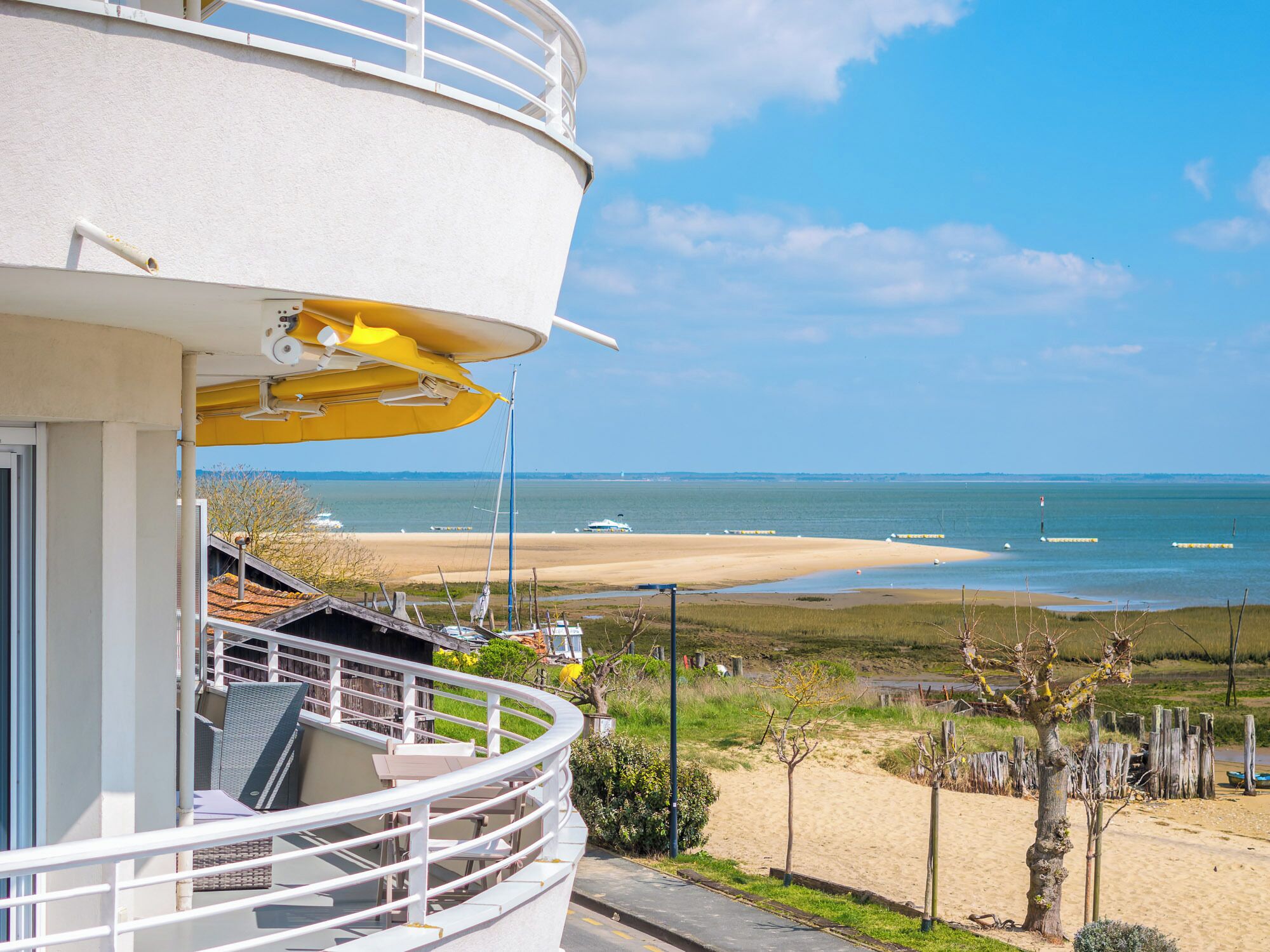 A seaside hotel with a balcony, a view of the beach, and the ocean.