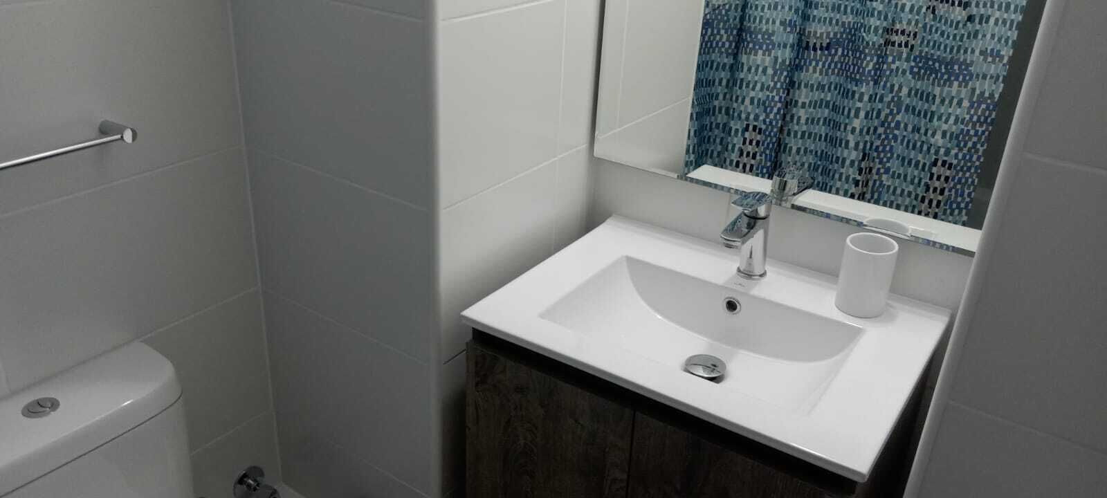 Un bany amb un vàter, un lavabo i un mirall.