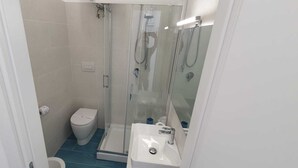 A small bathroom with a toilet, a shower, and a sink. - B&B VISTAMARE - (SEA VIEW) 250 meters from the center (San Nicola Arcella)
