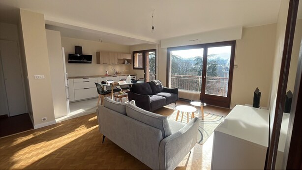 Un appartement moderne comprenant un espace de vie, une cuisine et un balcon.