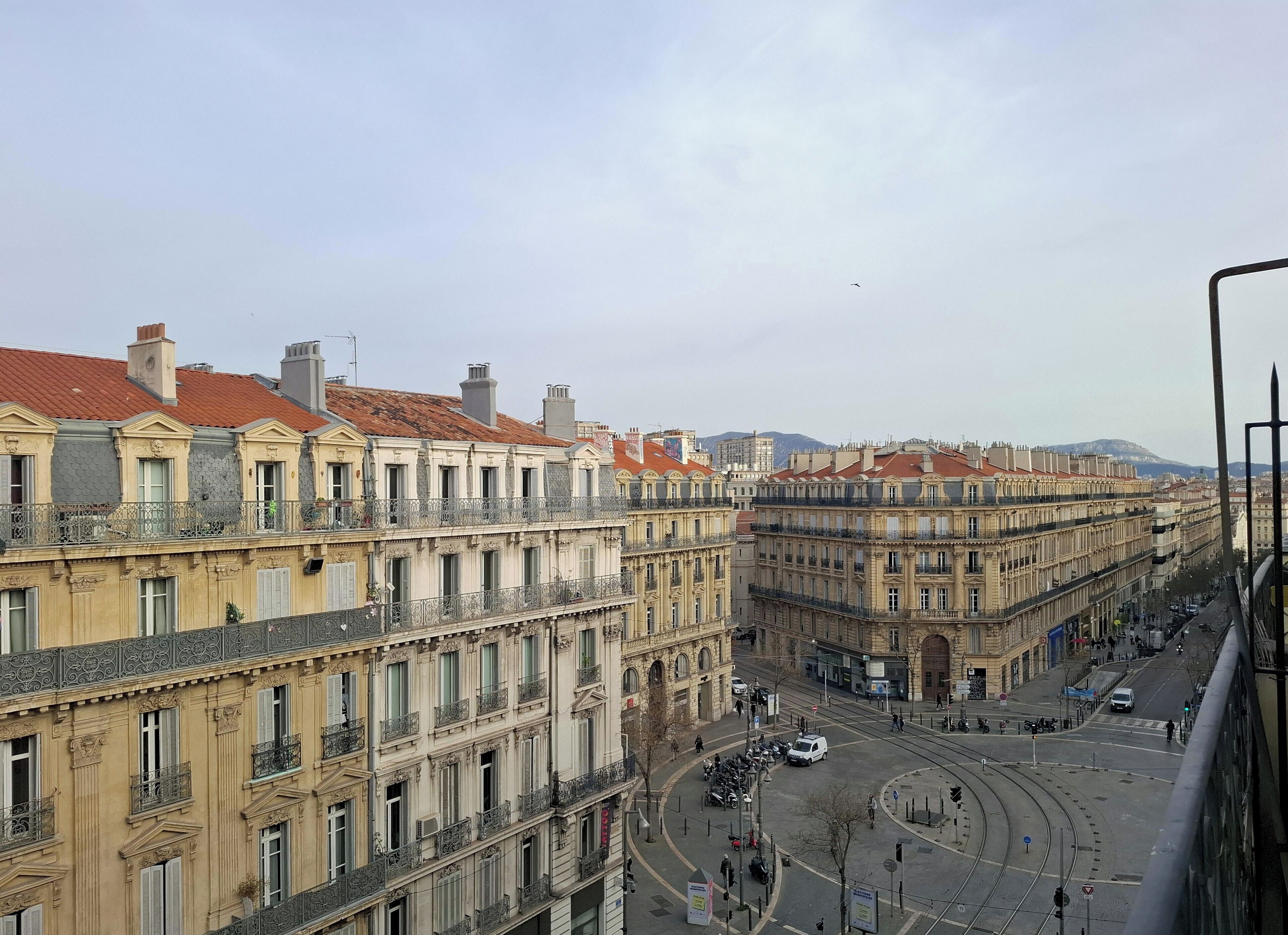 A city street with historic buildings, a tram, and a clear sky.