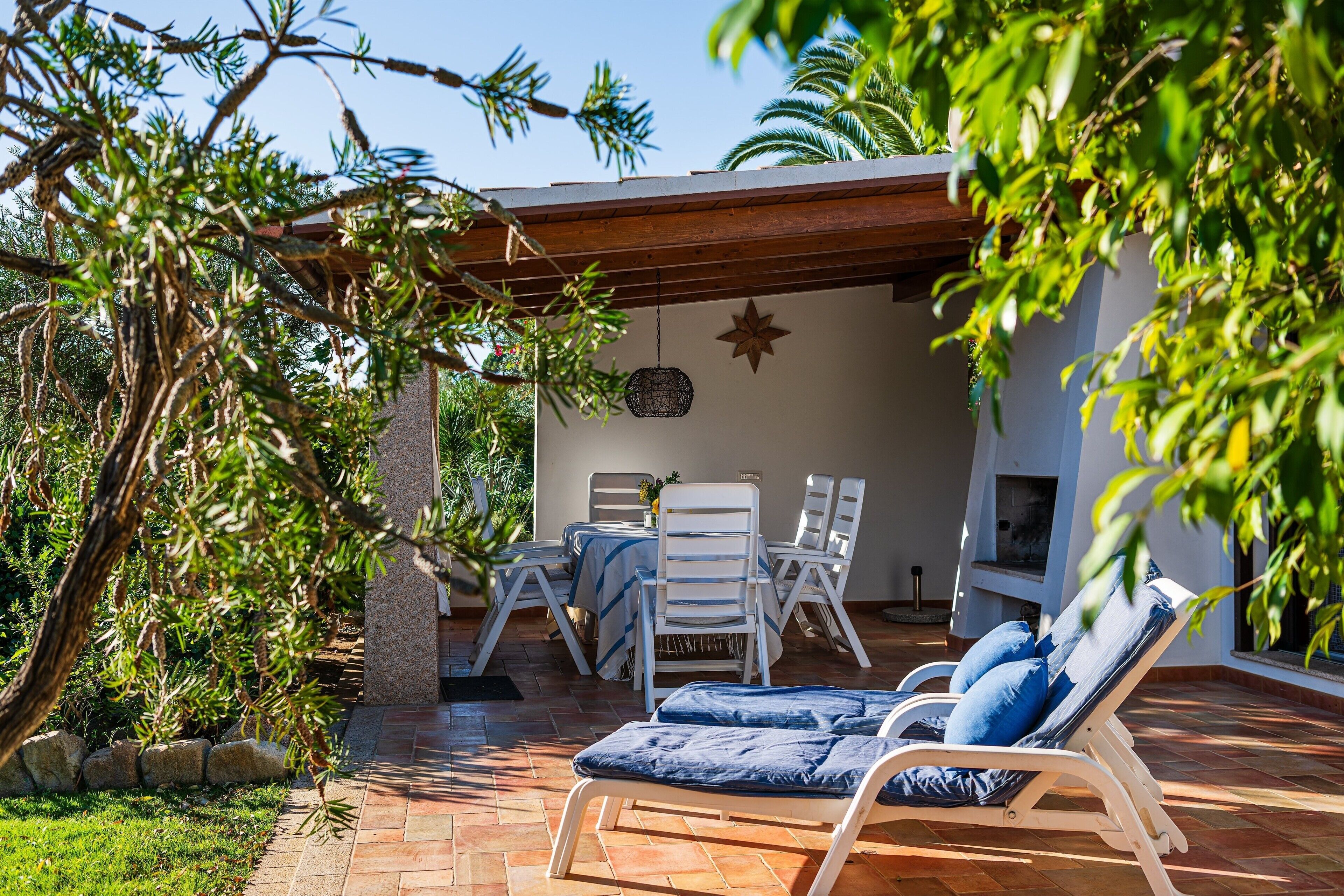 An outdoor patio with a table and chairs, a hanging light fixture, and a star decoration.
