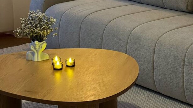 A sofa, a table with candles, and a floor lamp in a room. - Bright & Spacious Retreat Near Santa Claus Village (Rovaniemi)