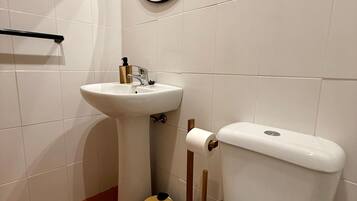 Un baño con inodoro, lavamanos y espejo.