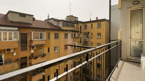 A multi-story residential building with balconies, a tiled roof, and a visible window with a curtain. - GuestHost - Comfortable 60m2 apartment, ideal for 4, on the 4th floor of a building with lift (steps to reach it). Located in Fiera Milano City between Portello and CityLife, a historic exhibition area now transformed into the Allianz MiCo convention cen (Milan)
