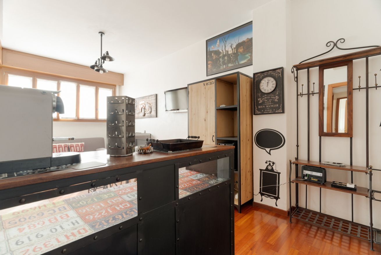 Una cocina con armarios de madera, encimera negra y una radio antigua.