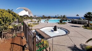 Ein Resort mit einem großen Pool, einem Kakteengarten und einem markanten, weiß gefärbten Gebäude mit gewölbter Dachform.