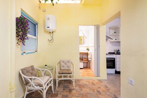 A compact kitchen with white cabinets, a stove, and a sink. - Home2Book Charming Apt with Interior Patio (San Andres de Tenerife)