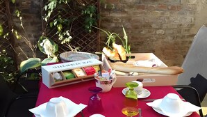 Una mesa lista para una comida, con mantel rojo, platos blancos y una caja de té Clivita.
