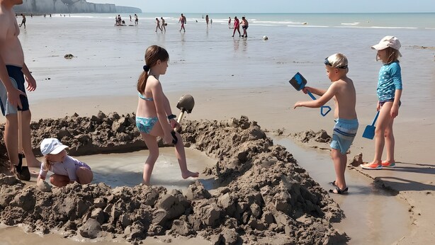 A sandy beach with children playing and building sand structures.