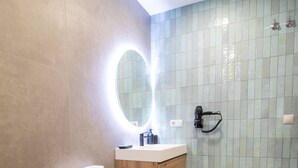A modern bathroom with a toilet, sink, and shower area. - Favara 1 by Concept Flats (Valencia)