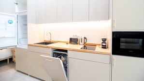 A compact kitchen with a dishwasher, a toaster, a kettle, and a microwave. - Favara 1 by Concept Flats (Valencia)
