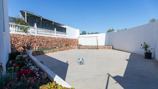 An outdoor patio with a soccer ball, a white fence, and a stone wall. - Modern Holiday Home in Almeria With Pool (Pechina)