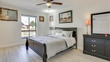 Une chambre à coucher avec un lit, un ventilateur de plafond, une commode et une fenêtre.