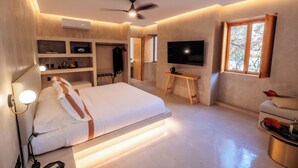A modern bedroom with a bed, built-in shelves, a desk, a TV, and a ceiling fan. - Casa Rosario Bed & City Oaxaca (Oaxaca)