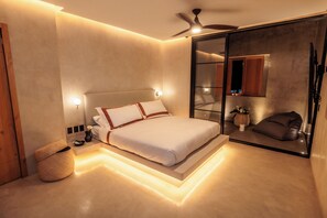 A modern bedroom with a bed, bedside lamps, a ceiling fan, and a large mirror. - Casa Rosario Bed & City Oaxaca (Oaxaca)