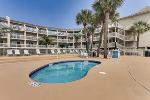 A hotel with a pool, multiple balconies, and palm trees. - Steps to Shore & Restaurants: Coligny Beach Gem! (Hilton Head Island)