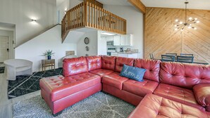 A modern living room with a red leather sectional sofa, a staircase, and a wooden wall. - Near Hiking! Family-friendly Pagosa Springs Haven (Pagosa Springs)