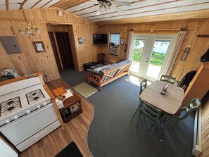 LâintĂ©rieur dâune cabine comprenant une cuisine, un coin repas et un canapĂ©-lit.