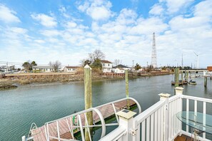Une vue sur la rivière depuis une jetée, avec une passerelle en bois, une balustrade blanche et une table en verre.