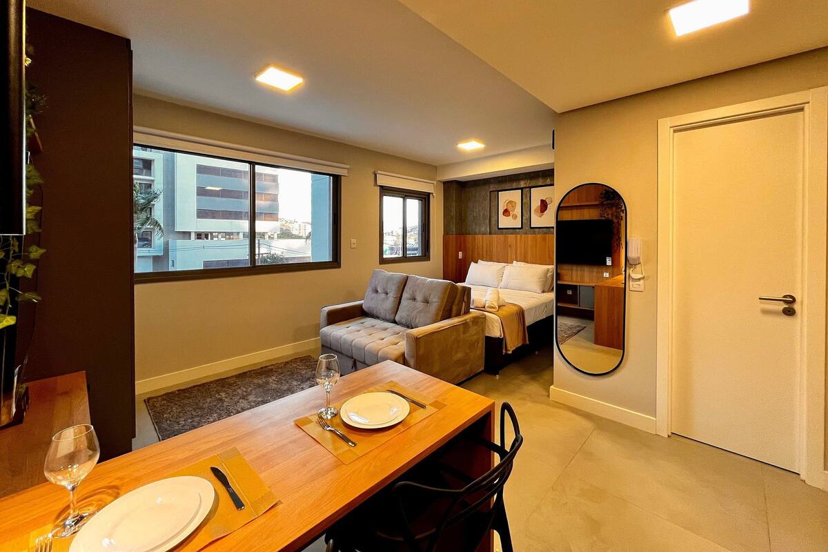 Une chambre d’hôtel comprenant un coin repas, un canapé, un lit, un miroir et une vue sur l’extérieur.