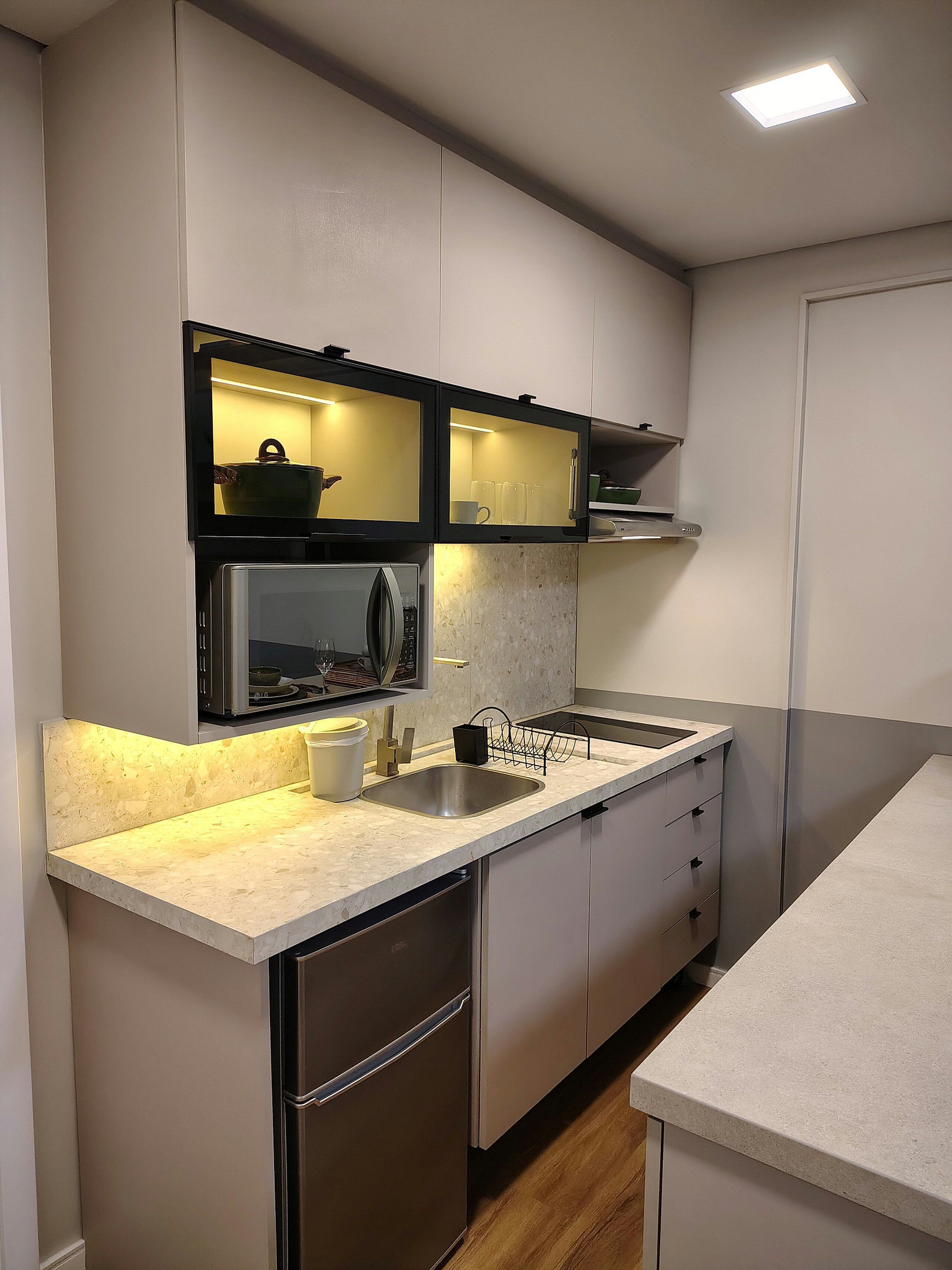 A modern kitchen with a built-in microwave, stainless steel sink, and a dishwasher.