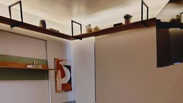 Uma sala de estar moderna com um sofá, mesa de centro e uma TV de tela plana na parede.