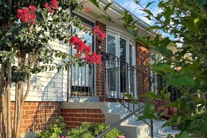A residential building with a brick facade, large windows, and a staircase leading to the entrance. - Charming Boutique Home in West End Alexandria! (Alexandria)