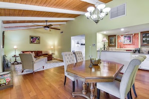 A dining area with a wooden table, chairs, and a chandelier. - 5 Mi to Fresno State: Family Gem w/ Backyard Oasis (Fresno)