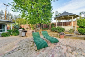 A patio with two green lounge chairs, a barbecue grill, and a gazebo. - 5 Mi to Fresno State: Family Gem w/ Backyard Oasis (Fresno)