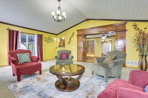 A living room with a glass coffee table, two armchairs, a red armchair, and a yellow wall. - 6 Mi to Rickenbacker Airport! Columbus Area Home (Groveport)