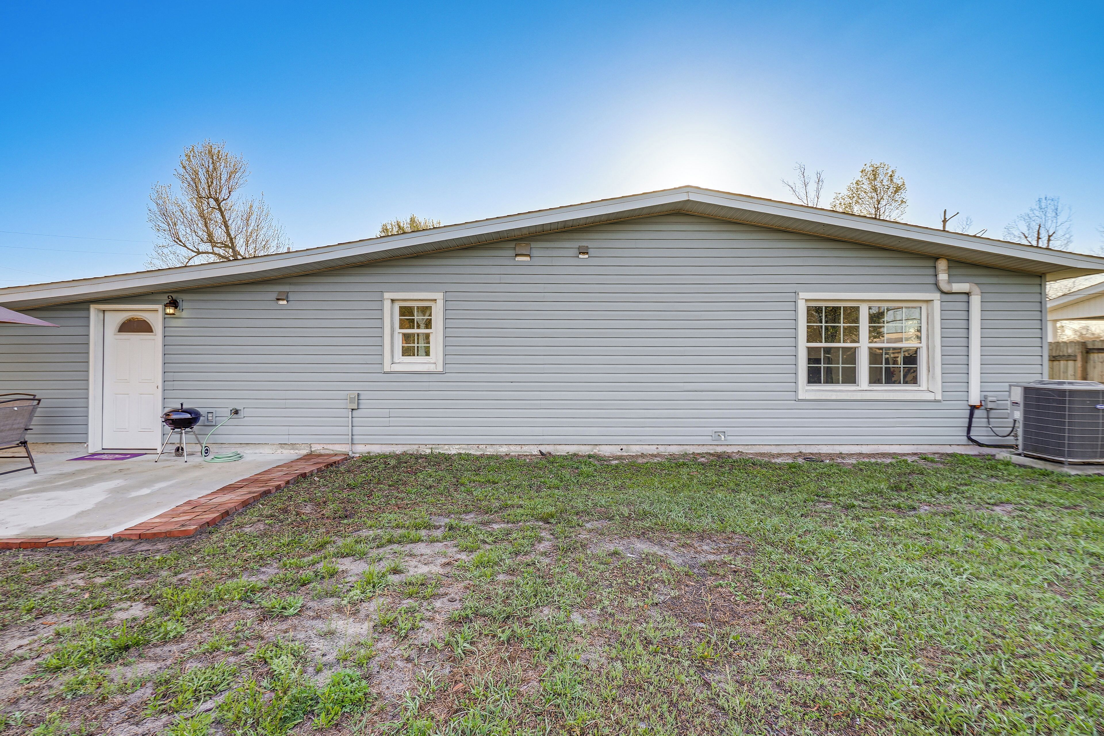 A single-story house with a front porch, a small attached garage, and a clear sky.